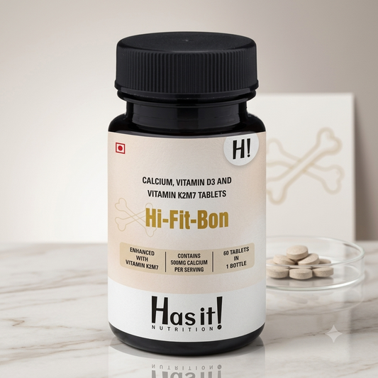 A bottle of Has it! Nutrition Hi-Fit-Bon dietary supplement with a black cap and a beige and white label, set on a marble surface with tablets in a glass dish in the background.