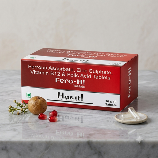 Hasit! Fero-H! Tablets box in red and white packaging, displayed on a marble surface with a walnut, red berries, and a small dish of tablets nearby.