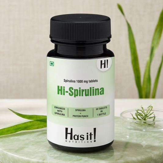 A bottle of Hi-Spirulina dietary supplement by Has it! Nutrition, placed on a light marble surface with blurred green leaves in the background.