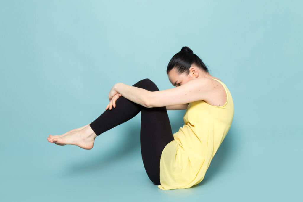 A person doing yoga pose, holding knee to strengthen bones and relieve knee pain